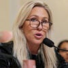 Marjorie Taylor Greene in a black outfit speaks at a House hearing.