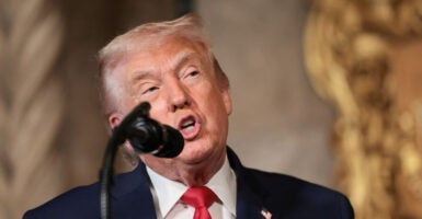 Close-up of Donald Trump speaking into a microphone.