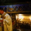 A priest stands near the figure of the baby Jesus at the Grotto in Bethlehem.