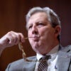 Sen. John Kennedy chews on the end of his eyeglasses during a hearing.