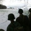 Black-and-white photo of U.S. soldiers overlooking site of Battle of the Bulge.