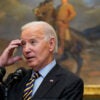 Joe Biden with his right hand at his forehead.