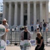 Pro-life activists kneel and stand outside the U.S. Supreme Court.