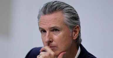 Close-up of Gavin Newson resting his chin in his hand. A federal judge issued a class-wide injunction blocking school districts from requiring teachers to hide students' gender identities from parents, in a blow to Gov. Gavin Newsom's transgender secrecy policy.