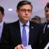 Speaker of the House Mike Johnson walks down a capitol hallway.