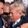 Republican presidential candidate and former U.S. President Donald Trump is assisted by guards during a campaign rally at the Butler Farm Show in Butler, Pennsylvania, U.S., July 13, 2024. REUTERS/Brendan McDermid