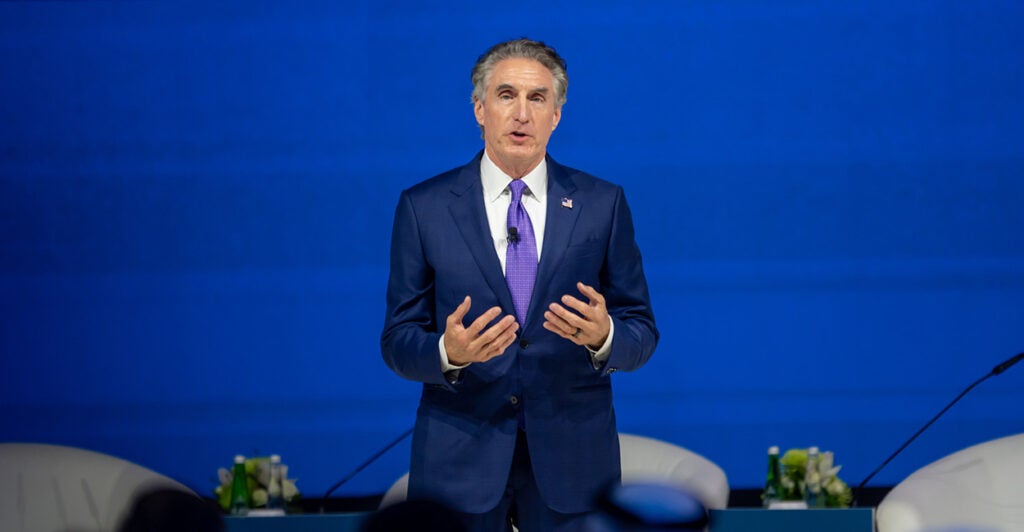 Doug Burgum stands against a blue background.