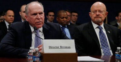 Then-Director of National Intelligence James Clapper watches then-CIA Director John Brennan speaks during a congressional hearing.
