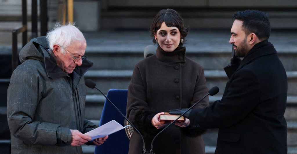 Zohran Mamdani is sworn-in as NYC mayor by socialist Bernie Sanders as his wife looks on, holding a Koran.