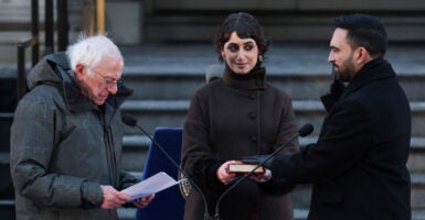 Zohran Mamdani is sworn-in as NYC mayor by socialist Bernie Sanders as his wife looks on, holding a Koran.