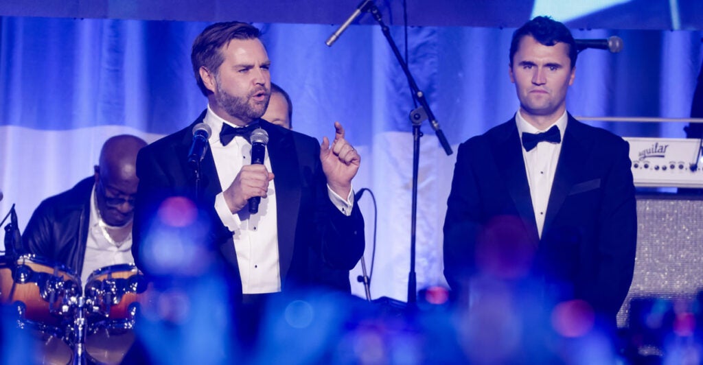 JD Vance speaks as Charlie Kirk looks on at a pre-Inauguration party in 2025.