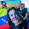 Venezuelans in Florida cheer and wave a flag with the face of opposition leader Maria Corina Machado.