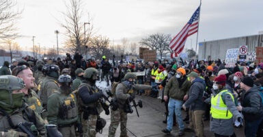 ICE agents clash with protesters on a street in Minneapolis.