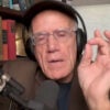 Victor Davis Hanson in his studio with his left hand raised to make a point.