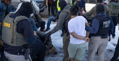 MINNEAPOLIS, MINNESOTA - JANUARY 13: Federal immigration agents clash with residents as they take a person into custody during a house raid on January 13, 2026 in Minneapolis, Minnesota. The Trump administration has sent an estimated 2,000 federal agents into the area, with more on the way, as they make a push to arrest undocumented immigrants in the region. (Photo by Scott Olson/Getty Images)