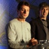 Google founders Google founders Larry Page and Sergey Brin sit at a table in front of a New York road map.