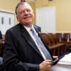 Rep. Tom Cole leans back with a smile while sitting at a table.