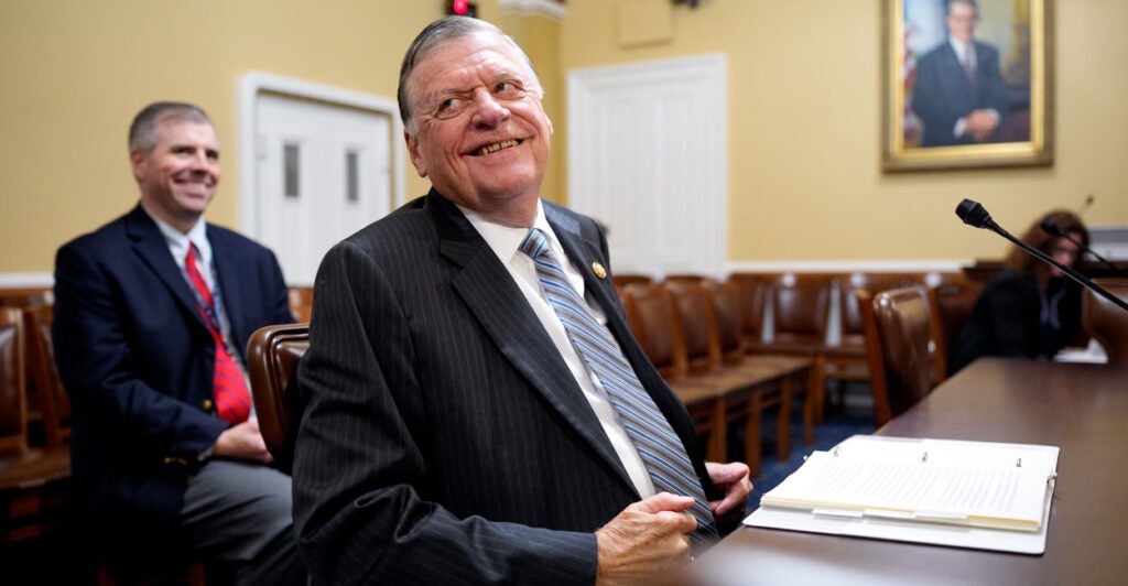 Rep. Tom Cole leans back with a smile while sitting at a table.