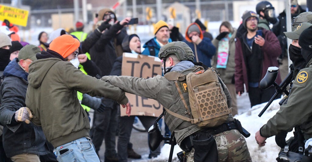 Protestors clash with federal agents outside the Bishop Henry Whipple Federal Building in Saint Paul, Minnesota, on January 8, 2026. A US Immigration and Customs Enforcement (ICE) agent shot and killed an American woman on the streets of Minneapolis January 7, leading to huge protests and outrage from local leaders who rejected White House claims she was a domestic terrorist. The woman, identified in local media as 37-year-old Renee Nicole Good, was hit at point blank range as she apparently tried to drive away from agents who were crowding around her car, which they said was blocking their way. (Photo by Octavio JONES / AFP via Getty Images)