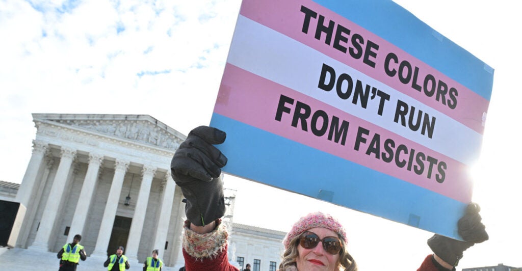 People hold signs outside the US Supreme Court on December 4, 2024 in Washington, DC, during oral argument on whether states can ban certain gender transition medical treatments for young people. The case was brought by three transgender teens, their parents and a doctor who are seeking to ensure health-care access they say is critical. (Photo by ROBERTO SCHMIDT / AFP) (Photo by ROBERTO SCHMIDT/AFP via Getty Images)