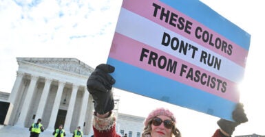People hold signs outside the US Supreme Court on December 4, 2024 in Washington, DC, during oral argument on whether states can ban certain gender transition medical treatments for young people. The case was brought by three transgender teens, their parents and a doctor who are seeking to ensure health-care access they say is critical. (Photo by ROBERTO SCHMIDT / AFP) (Photo by ROBERTO SCHMIDT/AFP via Getty Images)