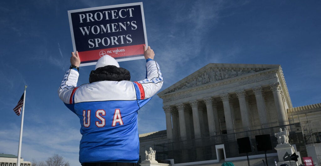 A man holds up a sign reading "Protect women's sports" outside of the Supreme Court