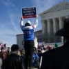 A man holds up a sign reading "Protect women's sports" as he demonstrates outside the US Supreme Court.