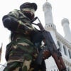 Security personnel stands guard outside a mosque.