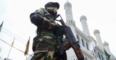 Security personnel stands guard outside a mosque.