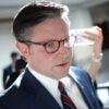 Speaker of the House Mike Johnson speaks to reporters in a capitol hallway.