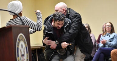 A man is tackled after spraying an unknown substance at US Representative Ilhan Omar (D-MN) (L) during a town hall she was hosting in Minneapolis, Minnesota, on January 27, 2026. US Democratic congresswoman Ilhan Omar was targeted during a speech late on January 27 by a man who sprayed an unidentified liquid at her from a syringe before being tackled by security guards, according to an AFP journalist at the scene. The man was led out of the premises as Omar, a frequent target of attacks by President Donald Trump, continued her speech saying 