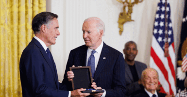 WASHINGTON, DC - JANUARY 4: Sen. Mitt Romney (R-UT) receives the the Presidential Medal of Freedom on behalf of his father, former Michigan Gov. George Romney, from U.S. President Joe Biden in the East Room of the White House on January 4, 2025 in Washington, DC. President Biden awarded 19 recipients with the nation's highest civilian honor. President Biden is awarding 19 recipients with the nation's highest civilian honor. (Photo by Tom Brenner/Getty Images)