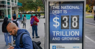 WASHINGTON, DC - OCTOBER 27: A view of a bus shelter at Pennsylvania Avenue and 22nd Street NW where an electronic billboard and a poster display the current U.S. National debt per person and as a nation at 38 Trillion dollars on October 27, 2025 in Washington, DC. (Photo by Jemal Countess/Getty Images for the Peter G. Peterson Foundation)