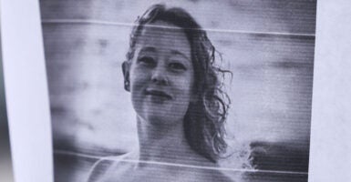 A picture of Renee Nicole Good is displayed near a makeshift memorial for Good, who was shot and killed at point blank range on January 7 by a US Immigration and Customs Enforcement (ICE) agent as she apparently tried to drive away from agents who were crowding around her car, in Minneapolis, Minnesota, on January 8, 2026. A US Immigration and Customs Enforcement (ICE) agent shot and killed an American woman on the streets of Minneapolis January 7, leading to huge protests and outrage from local leaders who rejected White House claims she was a domestic terrorist. (Photo by CHARLY TRIBALLEAU / AFP via Getty Images)