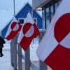 JANUARY 19: People walk past Greenlandic flags outside a shop in the city center on January 19, 2026 in Nuuk, Greenland. European leaders are scheduled to meet later this week to formulate their response to U.S. President Donald Trump's recent threat of punitive tariffs against countries who obstruct his desire to acquire Greenland. (Photo by Sean Gallup/Getty Images)