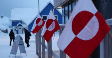 JANUARY 19: People walk past Greenlandic flags outside a shop in the city center on January 19, 2026 in Nuuk, Greenland. European leaders are scheduled to meet later this week to formulate their response to U.S. President Donald Trump's recent threat of punitive tariffs against countries who obstruct his desire to acquire Greenland. (Photo by Sean Gallup/Getty Images)