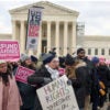 Pro-life activists stand with signs outside of the U.S. Supreme Court.