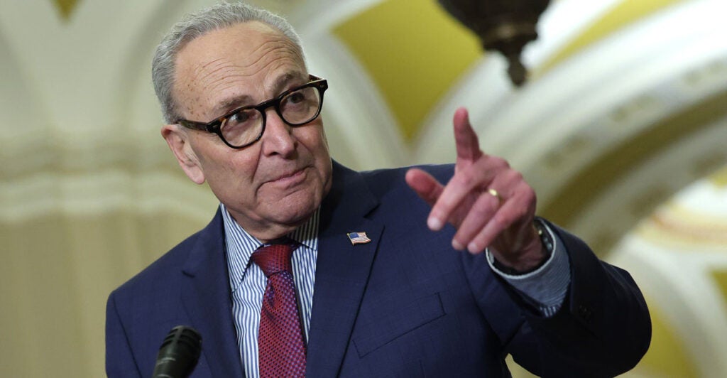 Sen. Chuck Schumer points as he speaks to reporters at a Capitol press conference.