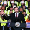 Vice President JD Vance stands at a lectern while factory members stand behind him.