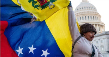 Woman holds Venezuelan flag at the U.S. Capitol.