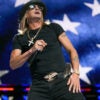 Kid Rock performs at Republican National Convention in front of large screen of American flag.