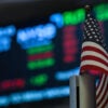 An American flag is displayed on a desk on the floor of the New York Stock Exchange (NYSE) at the opening bell on July 15, 2025, in New York City. Global stock markets went in different directions on Tuesday, as an uptick in US inflation suggested President Donald Trump's tariffs could be beginning to feed into the American economy. New York was generally trading higher on the back of healthy results from major US banks and buoyant news in the tech sector. The S&P 500 and Nasdaq were up, though the Dow Jones was struggling. Most Asian indices rose but Europe's stock markets slipped into the red late in the day. (Photo by ANGELA WEISS / AFP) (Photo by ANGELA WEISS/AFP via Getty Images)