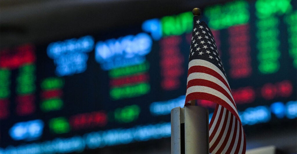 An American flag is displayed on a desk on the floor of the New York Stock Exchange (NYSE) at the opening bell on July 15, 2025, in New York City. Global stock markets went in different directions on Tuesday, as an uptick in US inflation suggested President Donald Trump's tariffs could be beginning to feed into the American economy. New York was generally trading higher on the back of healthy results from major US banks and buoyant news in the tech sector. The S&P 500 and Nasdaq were up, though the Dow Jones was struggling. Most Asian indices rose but Europe's stock markets slipped into the red late in the day. (Photo by ANGELA WEISS / AFP) (Photo by ANGELA WEISS/AFP via Getty Images)
