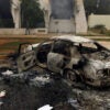 TOPSHOT - The wreckage of a burnt car is seen outside a building used by Ansar al-Sharia militia after it was torched by residents on November 25, 2013 in Benghazi. Military governor Colonel Abdullah al-Saidi declared a "state of alert" after Jihadist group Ansar al-Sharia attacked Libyan special forces in Benghazi, sparking an all-out battle in which at least five soldiers died, in what was the first such confrontation between the army and Libya's top jihadist group. AFP PHOTO/ABDULLAH DOMA (Photo by ABDULLAH DOMA / AFP) (Photo by ABDULLAH DOMA/AFP via Getty Images)