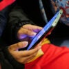 A young boy plays a video game on a smartphone while riding the subway in New York on January 29, 2024. (Photo by Charly TRIBALLEAU / AFP) (Photo by CHARLY TRIBALLEAU/AFP via Getty Images)