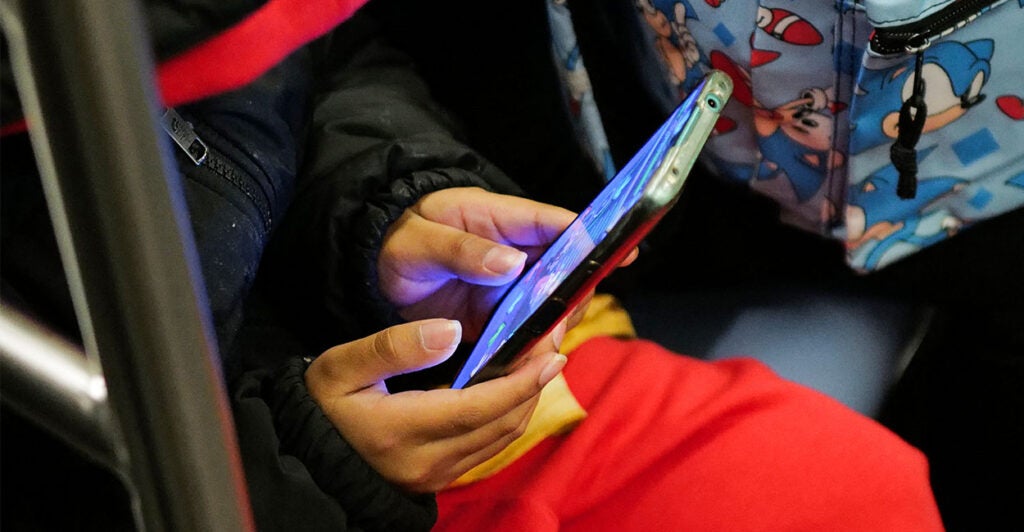 A young boy plays a video game on a smartphone while riding the subway in New York on January 29, 2024. (Photo by Charly TRIBALLEAU / AFP) (Photo by CHARLY TRIBALLEAU/AFP via Getty Images)