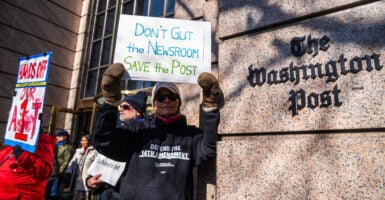 A male demonstrator holds a sign reading 