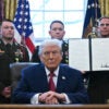 A service member holds an executive order by President Donald Trump signed during a Mexican Border Defense Medal presentation in the Oval Office on Dec. 15. (Photo by ANDREW CABALLERO-REYNOLDS / AFP via Getty Images)