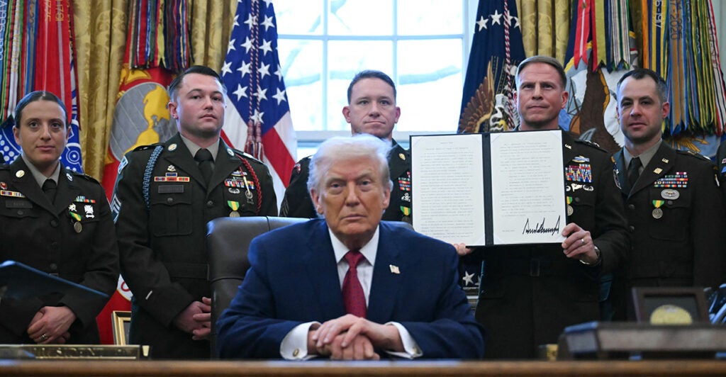 A service member holds an executive order by President Donald Trump signed during a Mexican Border Defense Medal presentation in the Oval Office on Dec. 15. (Photo by ANDREW CABALLERO-REYNOLDS / AFP via Getty Images)