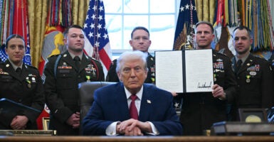 A service member holds an executive order by President Donald Trump signed during a Mexican Border Defense Medal presentation in the Oval Office on Dec. 15. (Photo by ANDREW CABALLERO-REYNOLDS / AFP via Getty Images)